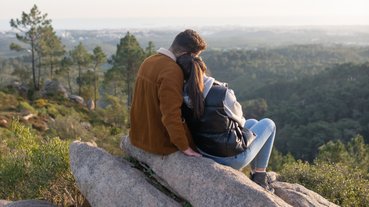 Casal contempla natureza do alto de uma montanha