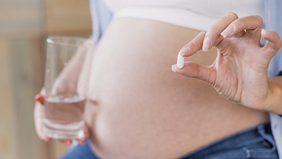 Mulher grávida segura comprimido