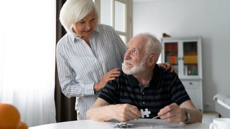 Casal idoso monta quebra-cabeças