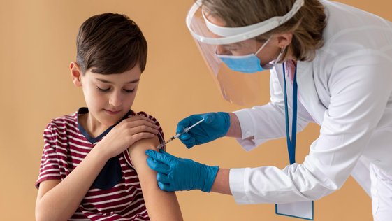 Menino recebe dose de vacina contra a covid